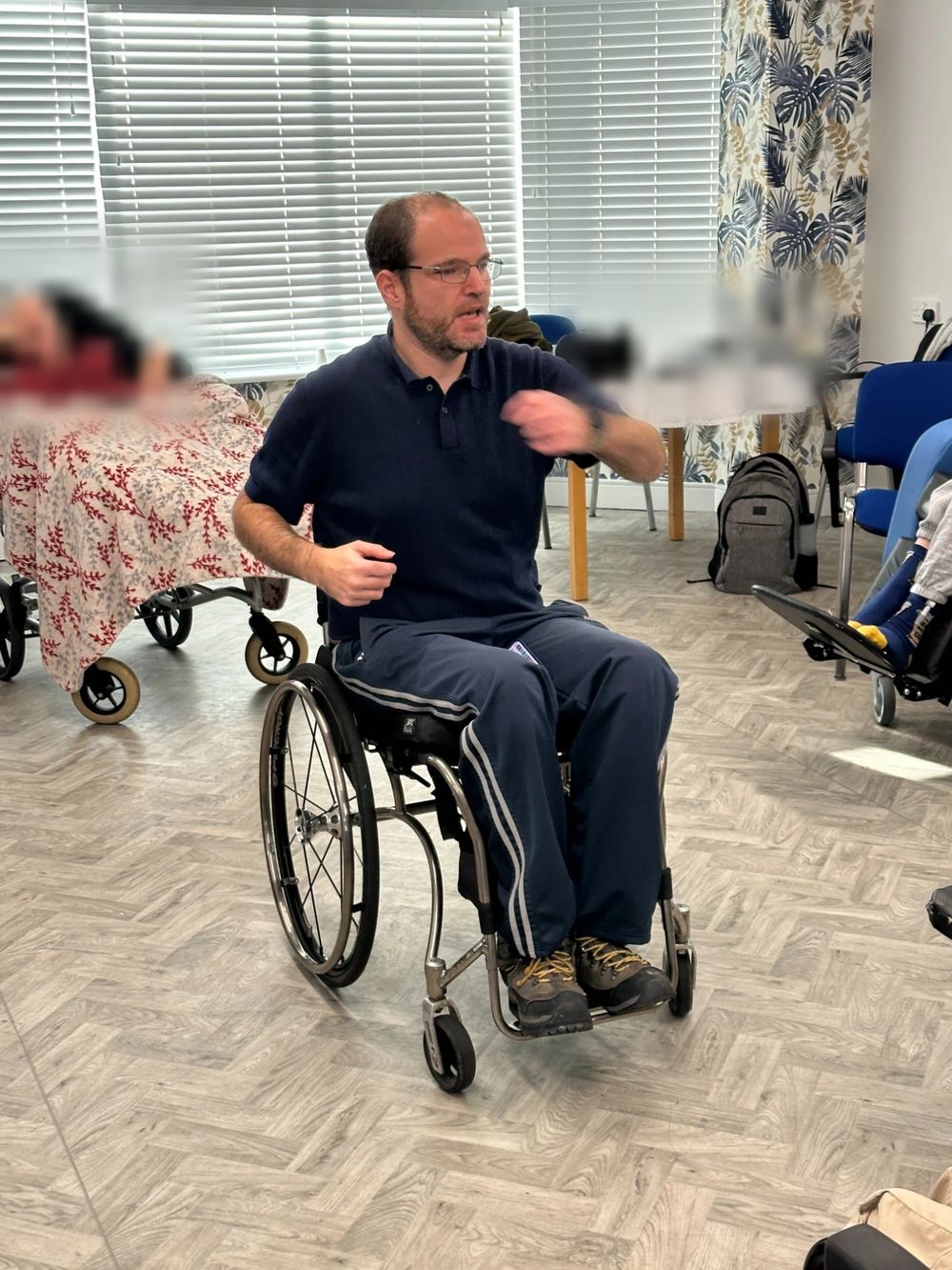 Mat Richards leading a chair-based exercise session in a care home lounge