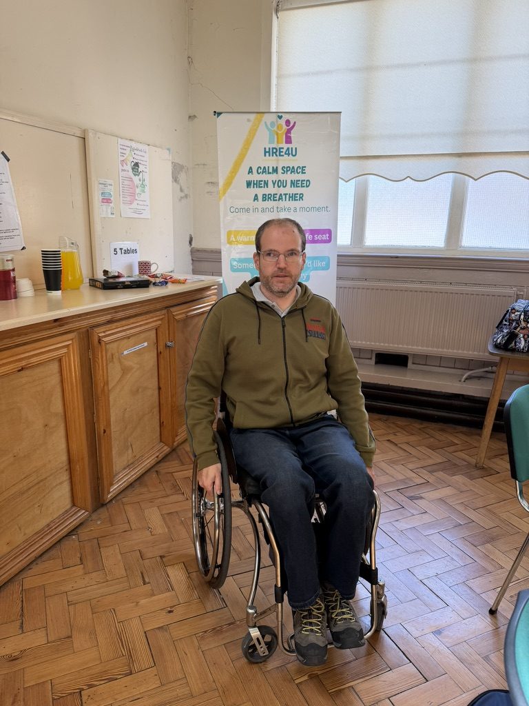 Mat Richards at a community session beside a HRE4U calm-space banner